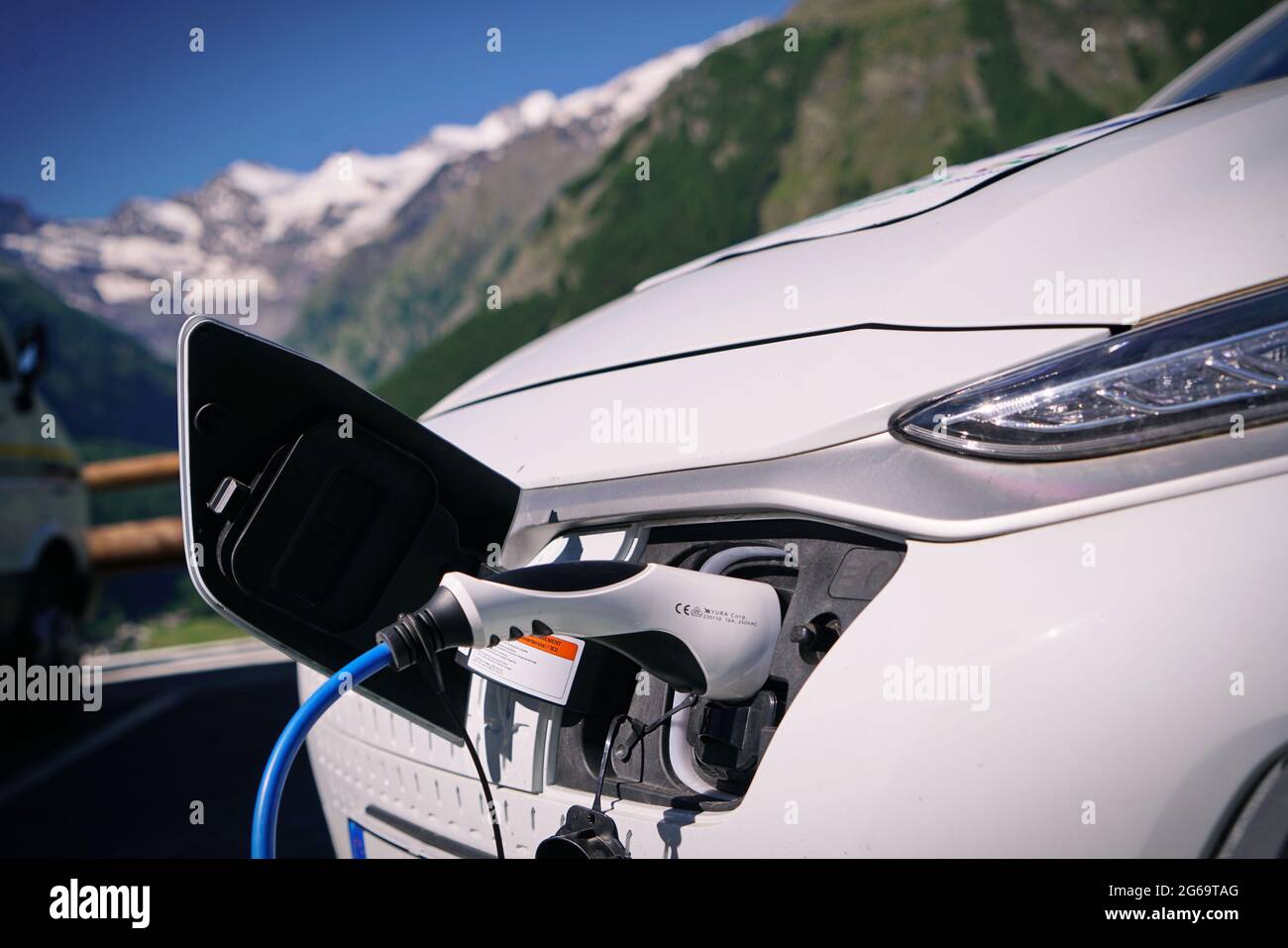 Electric car charging its battery with natural landscape, for green