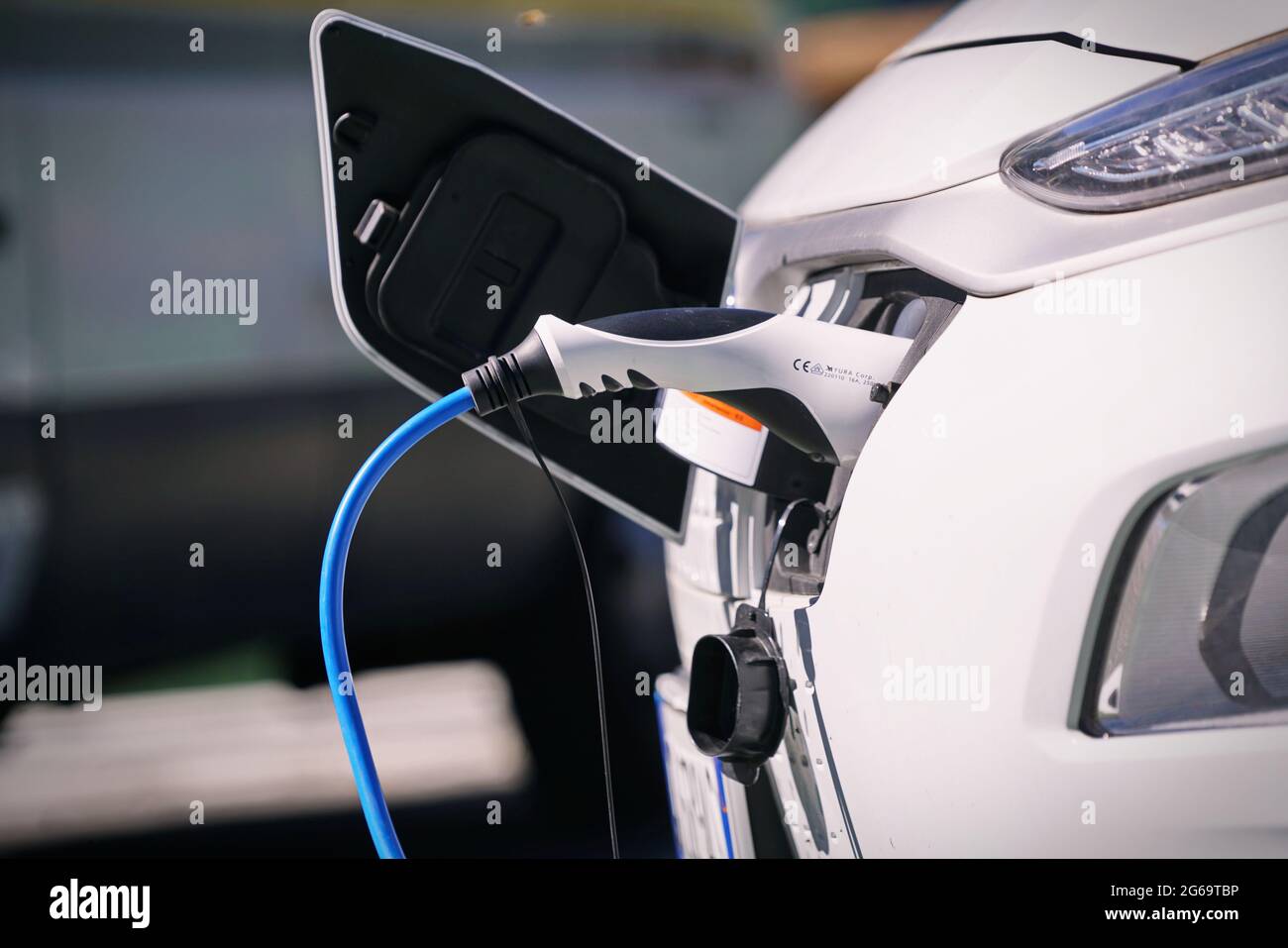 Electric car charging its battery with natural landscape, for green