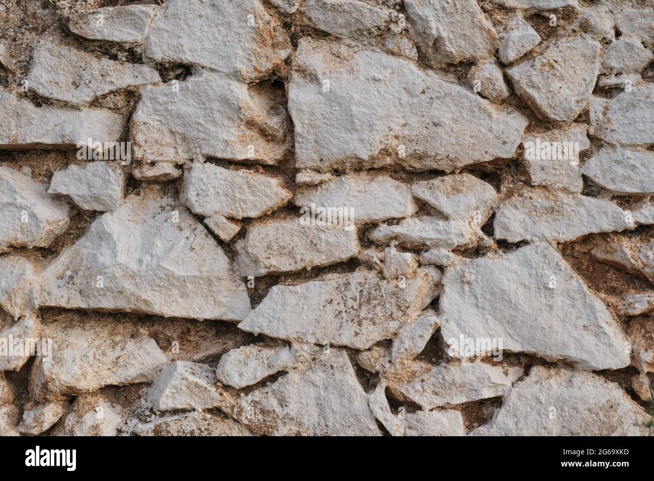 Old traditional limewashed stone wall, white rustic background or texture Stock Photo
