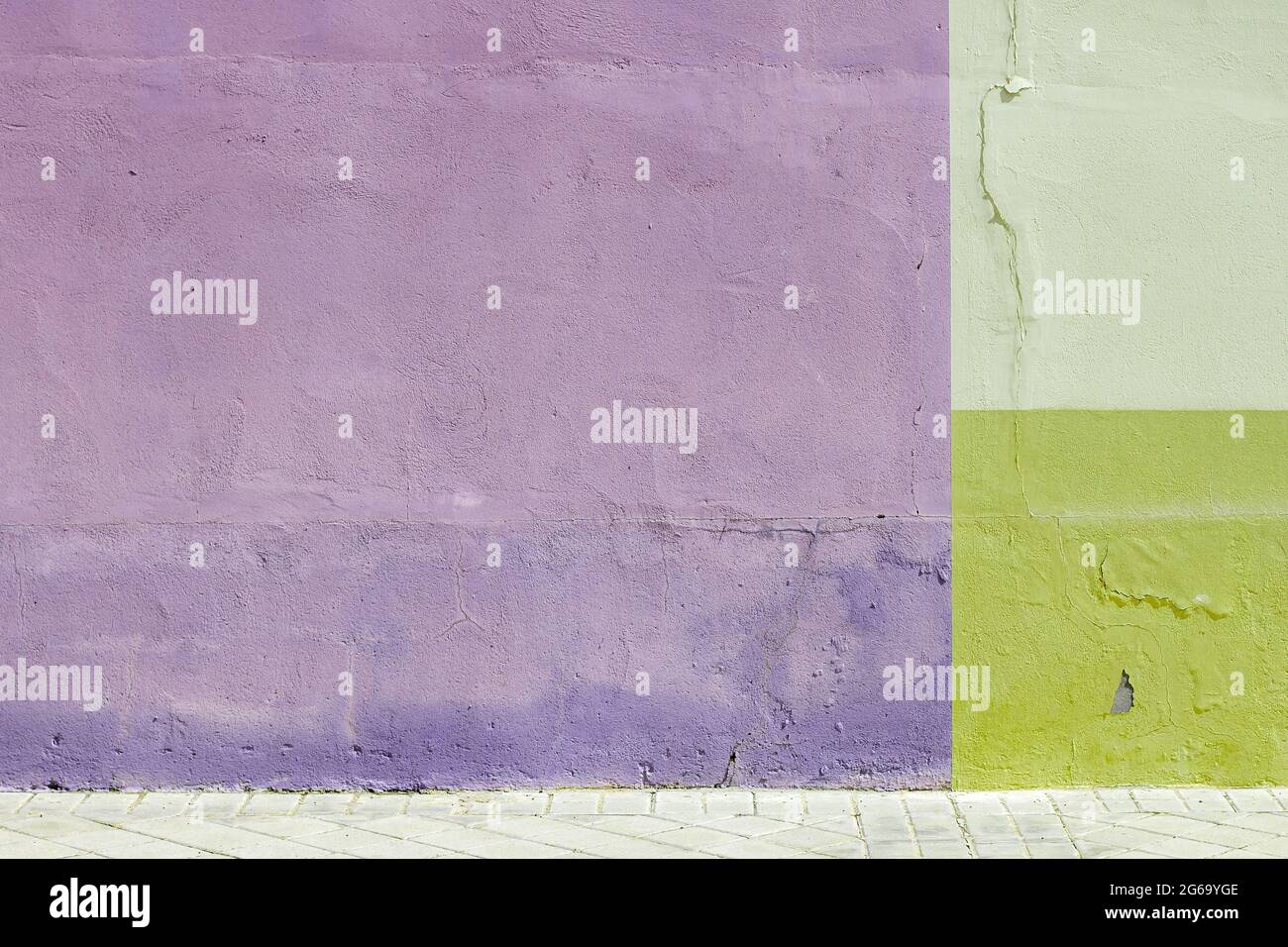 Viotet and green painted wall with tiled street floor, modern architecture detail, urban geometric abstract background or texture Stock Photo