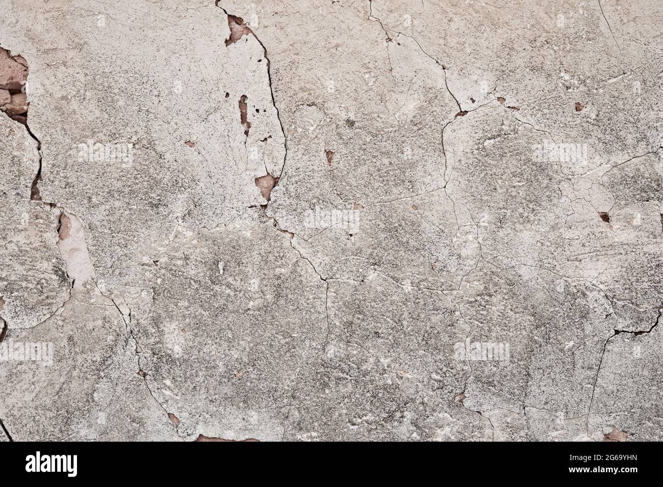 Old traditional limewashed stone wall with peeling plaster, white rustic background Stock Photo