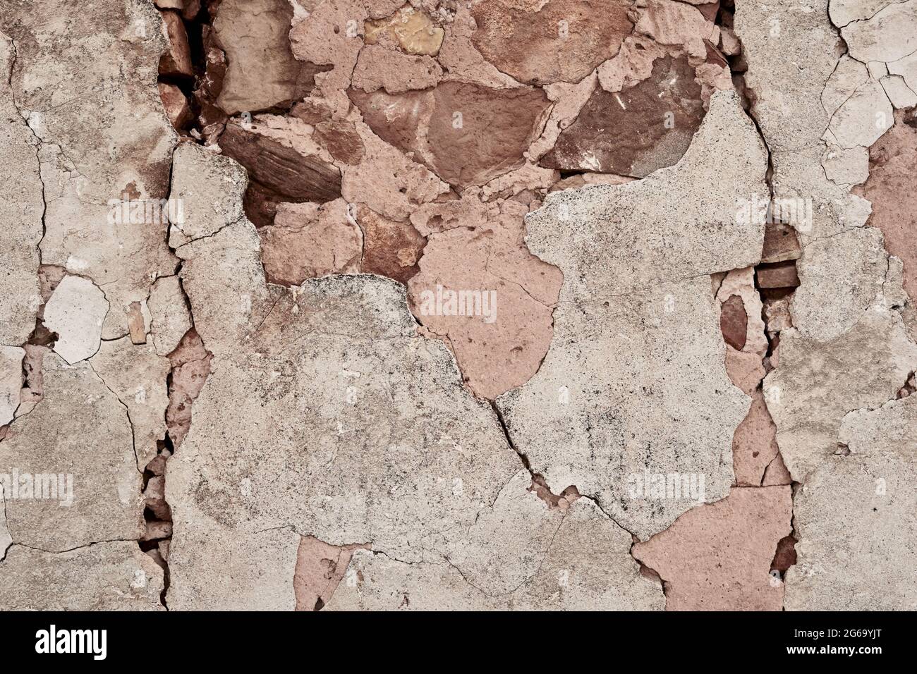 Old traditional limewashed stone wall with peeling plaster, white rustic background Stock Photo