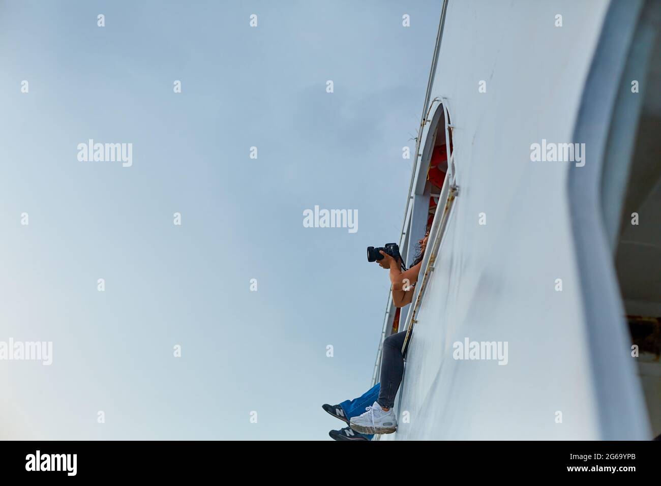 The couple are sailing on a pleasure ferry with their legs dangling from the deck of the second floor. Istanbul, Turkey - 28.07.2017 Stock Photo