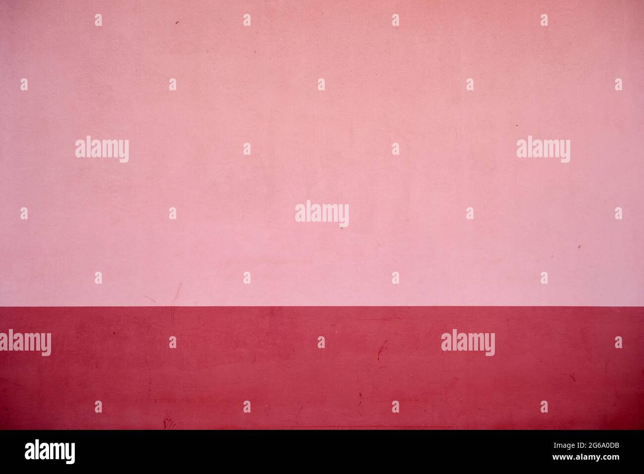 Pink concrete wall with red baseboard, abstract background or texture ...