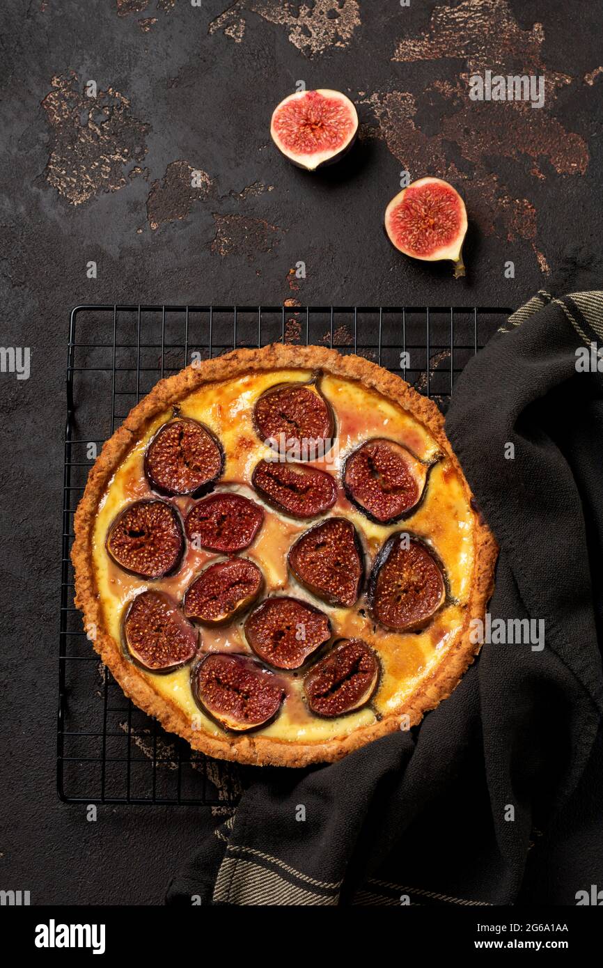 Homemade quiche tart with figs, cream cheese and honey on dark brown background. Vintage style. Top view Stock Photo