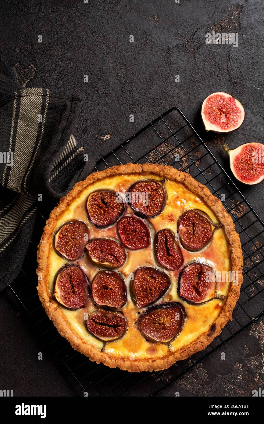 Homemade quiche tart with figs, cream cheese and honey on dark brown background. Vintage style. Top view Stock Photo