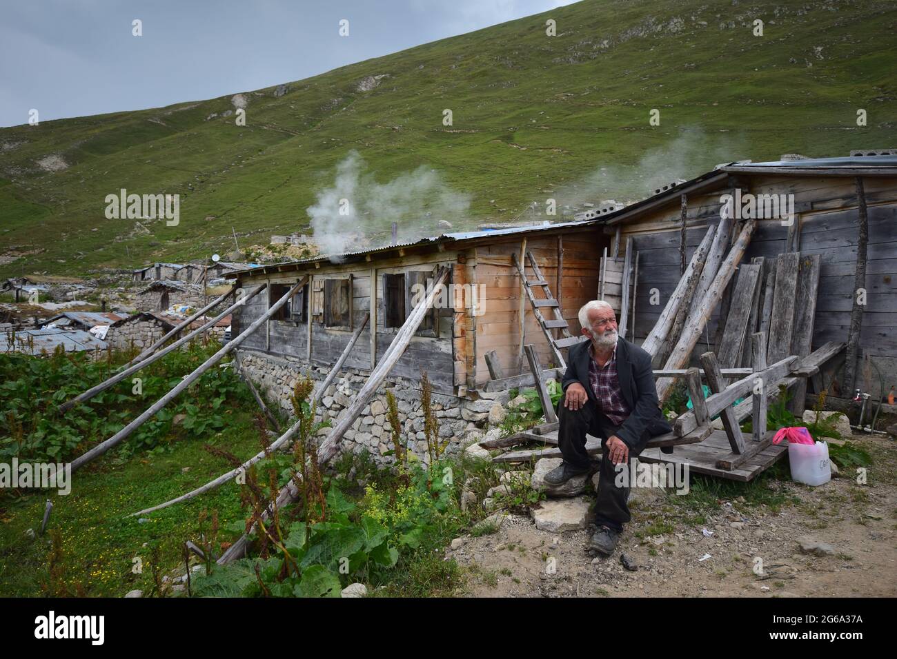 Rize, TURKEY - July 31, 2015: Avusor or Avusör is a plateau in the Çamlıhemşin district of Rize province. Old man sitting in front of his house in the Stock Photo