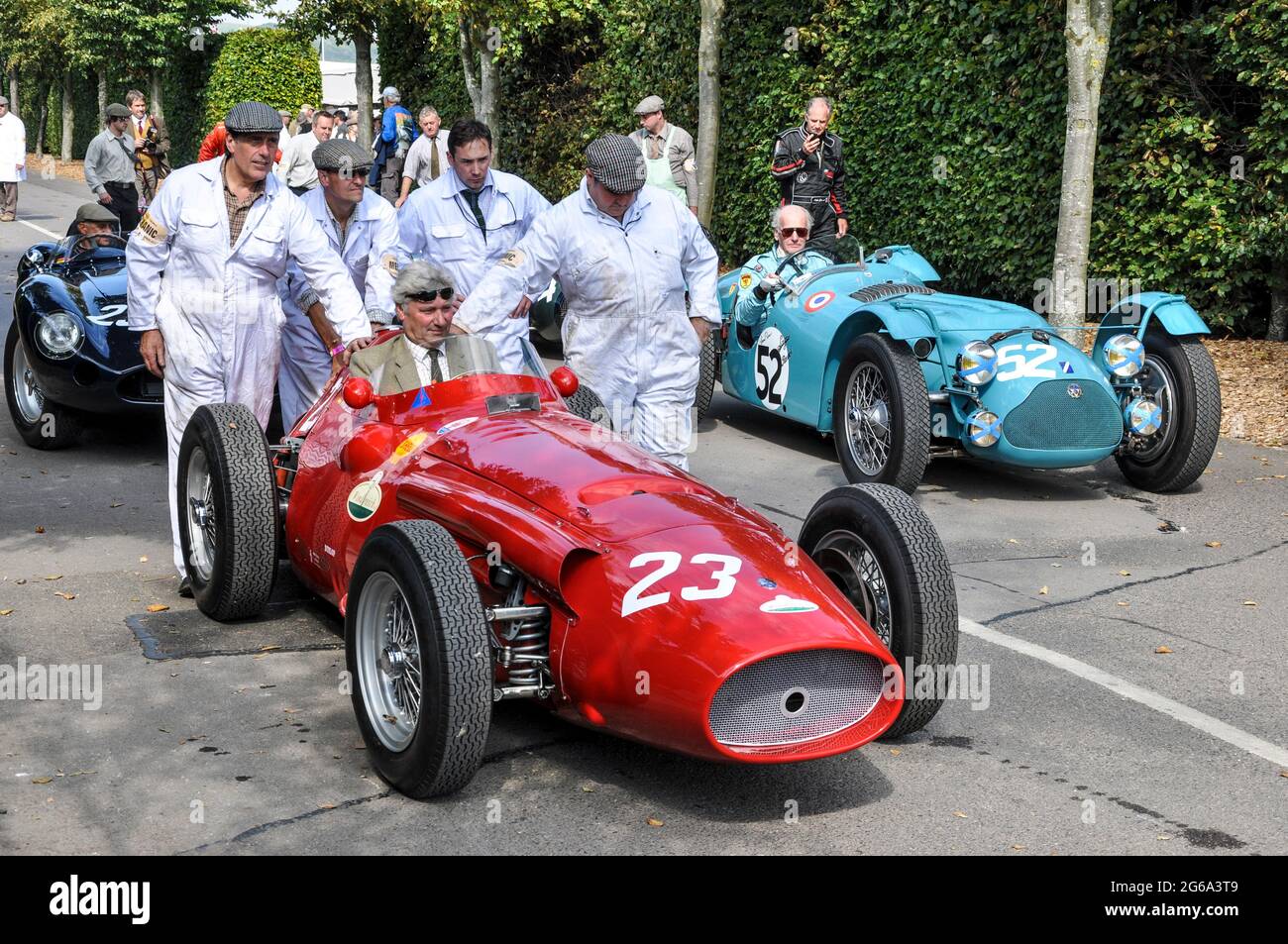 Maserati 250F of Willi Balz classic, vintage racing car pushing out for competing at the Goodwood Revival historic event, UK. Team crew support Stock Photo