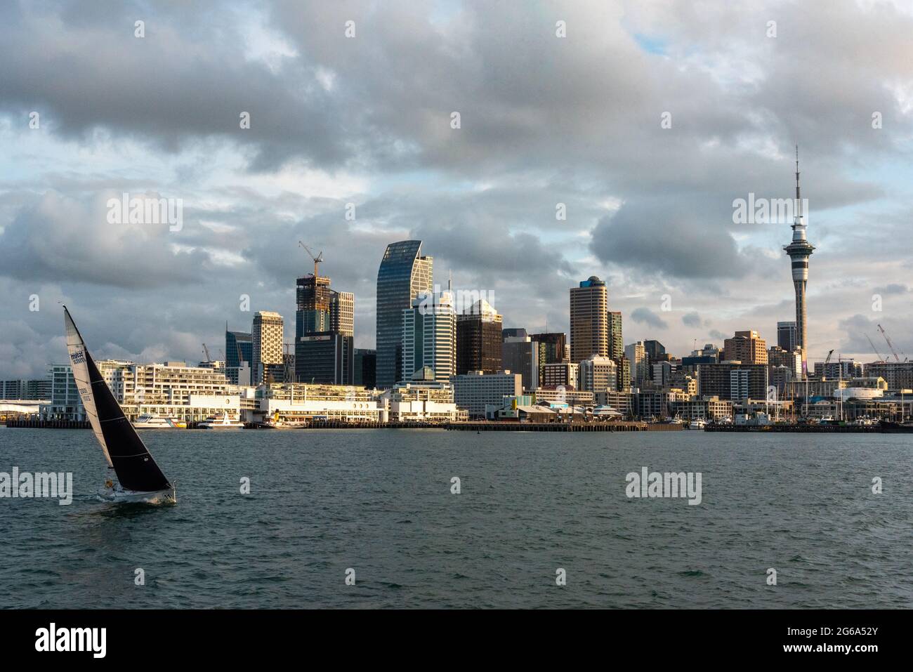 Famous skyline of Auckland Central Business District during sunset, people anjoying the warm summer evening on their sailboats, New Zealand Stock Photo