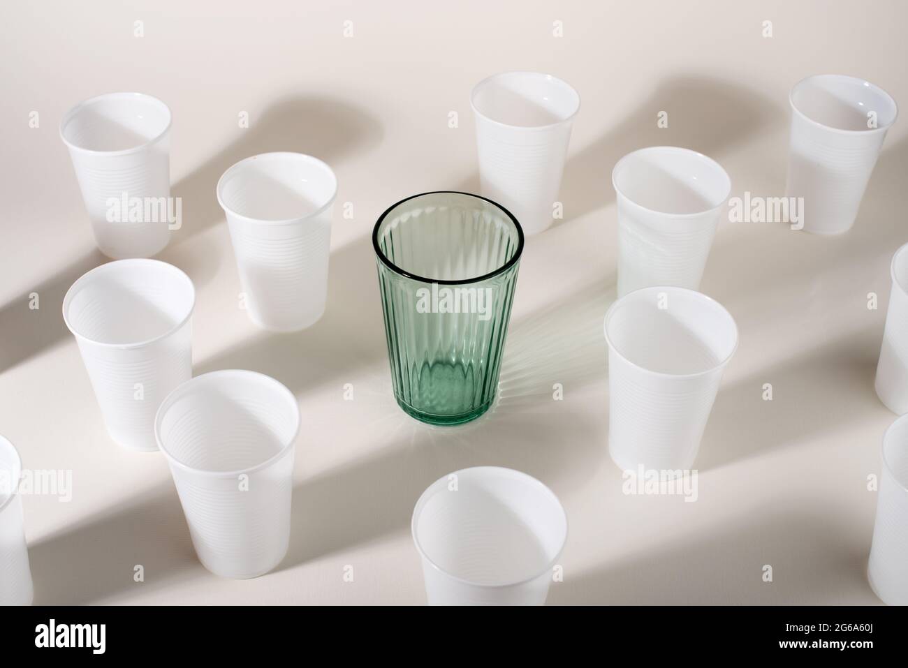 Glass among many plastic cups. Glass or plastic. Reusable versus