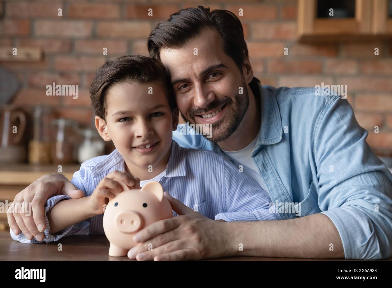 Happy dad and little son holding piggy bank, smiling Stock Photo - Alamy