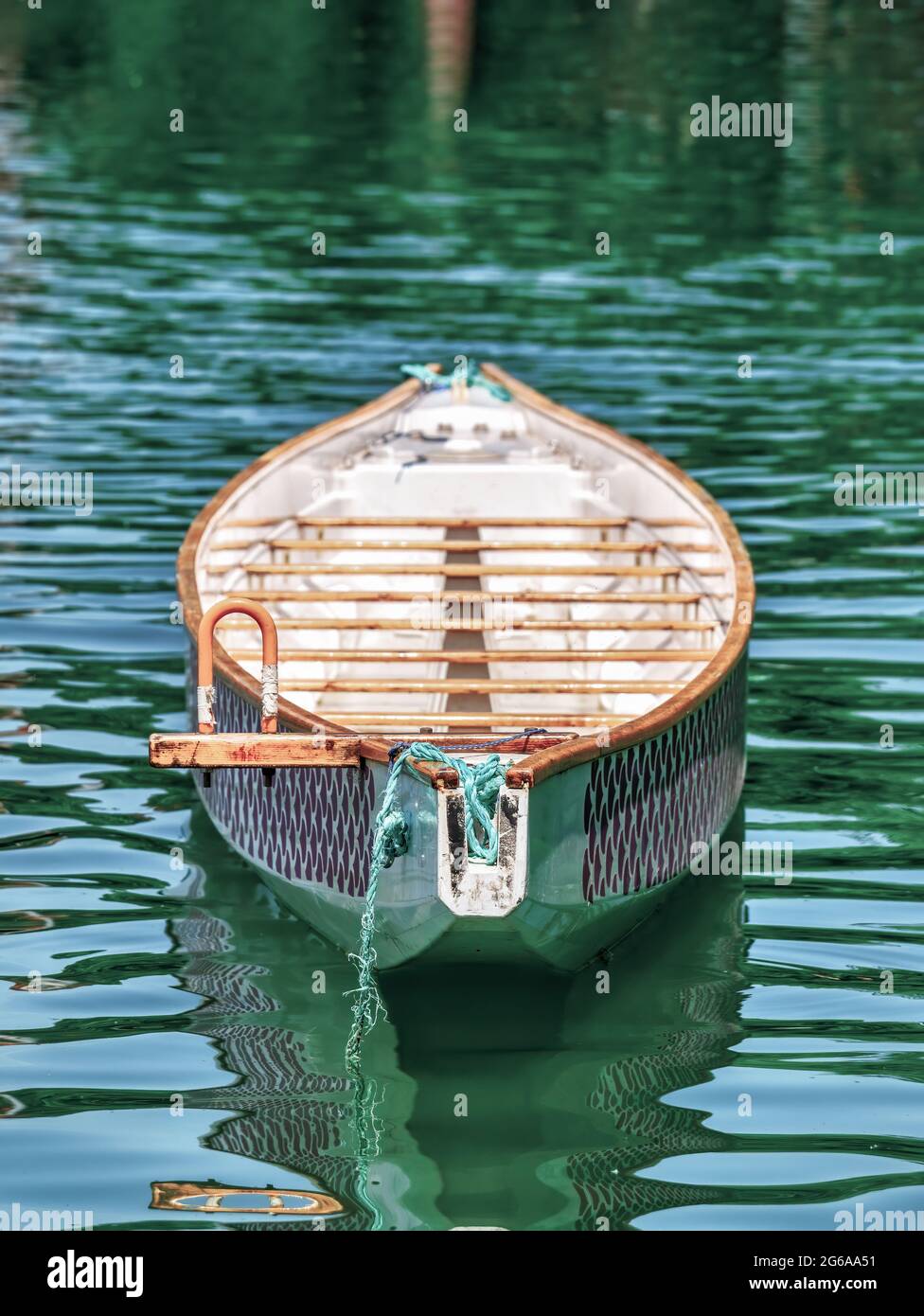 Old wooden boat floating on the turquoise water of a lake Stock Photo ...