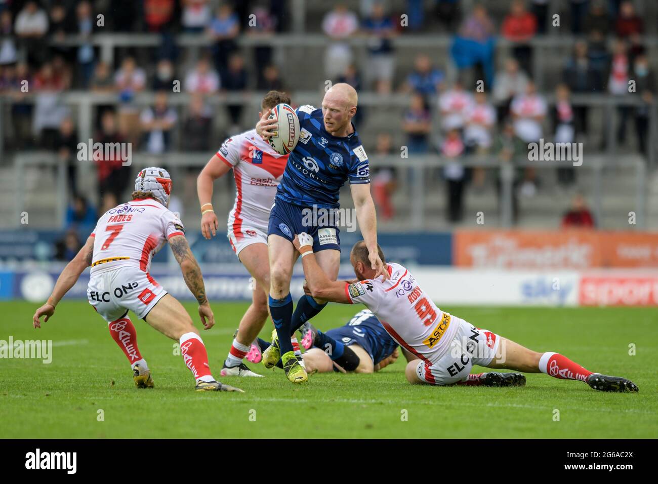 Liam Farrell (12) of Wigan Warriors is tackled by James Roby (9) of St ...