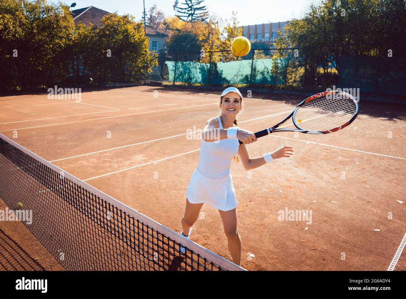 Woman hitting the tennis ball on the court Stock Photo