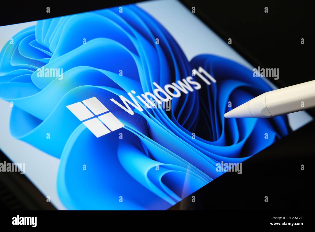 Windows 11 logo seen on the screen of tablet and user pointing at it with stylus. Stafford, United Kingdom, July 1, 2021 Stock Photo
