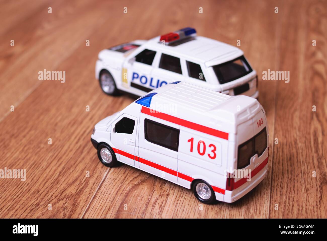Toy ambulances and police cars on wooden floor closeup Stock Photo Alamy