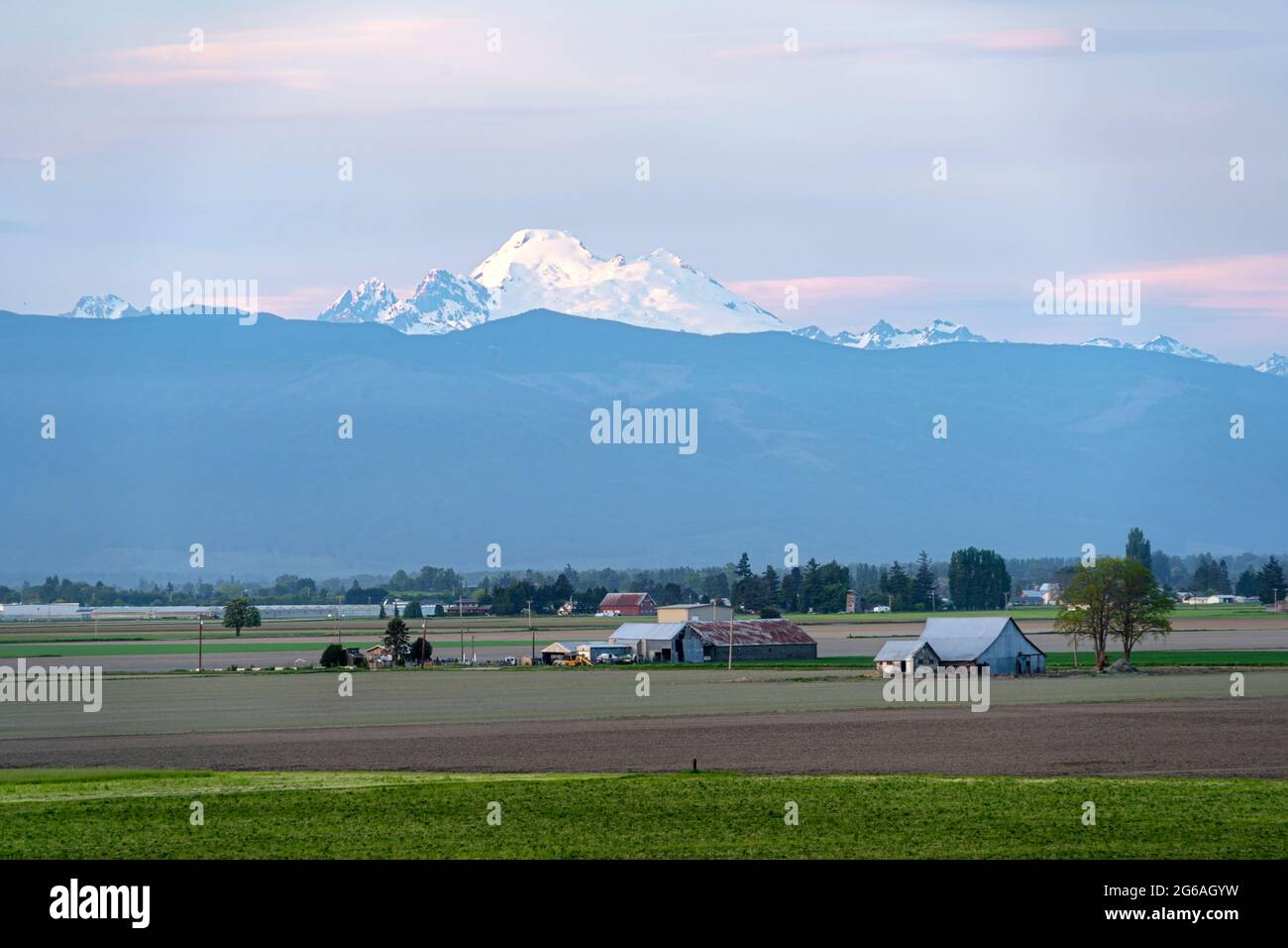 Mount Baker Jutting over a farm on a beautiful Pacific Northwest Stock Photo