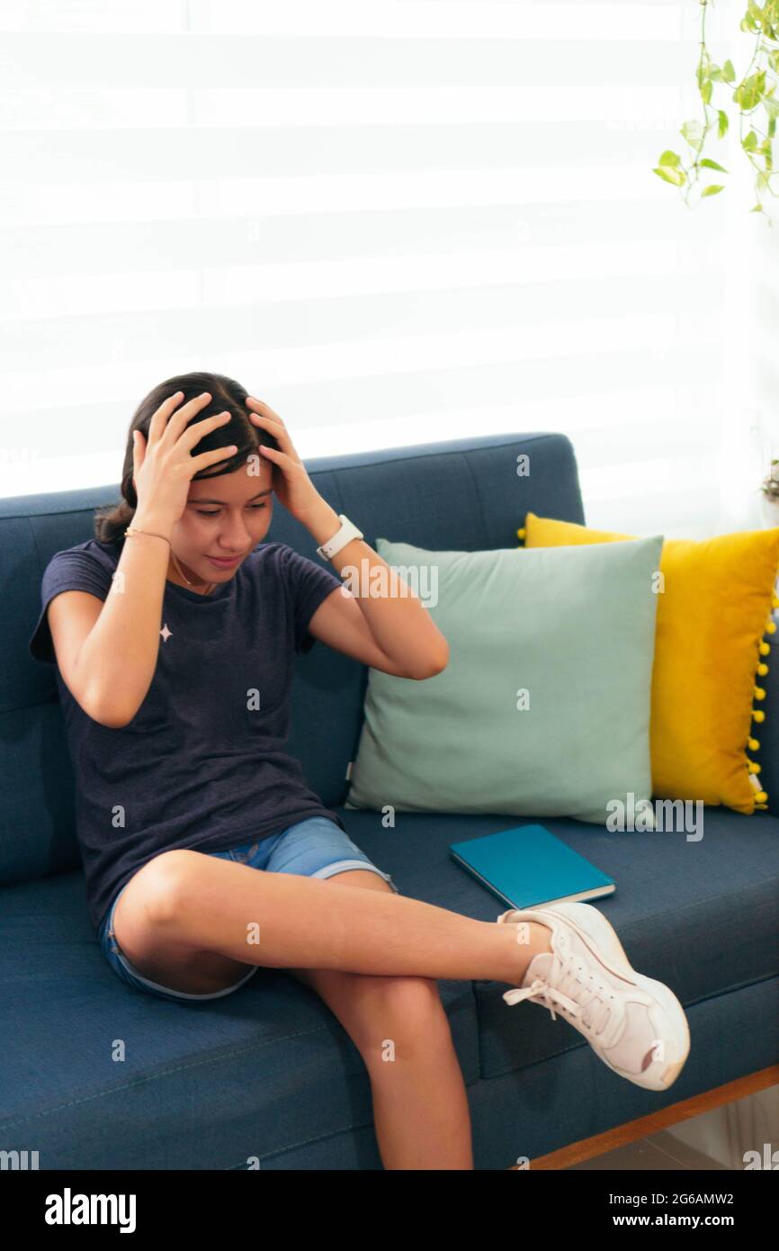 Teenage girl sitting on the sofa in surprise Stock Photo - Alamy