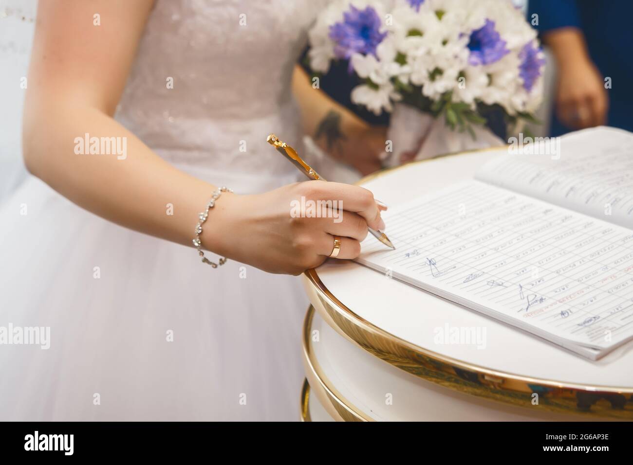 Bride's hands put signature on consent to marriage in registry office. Stock Photo