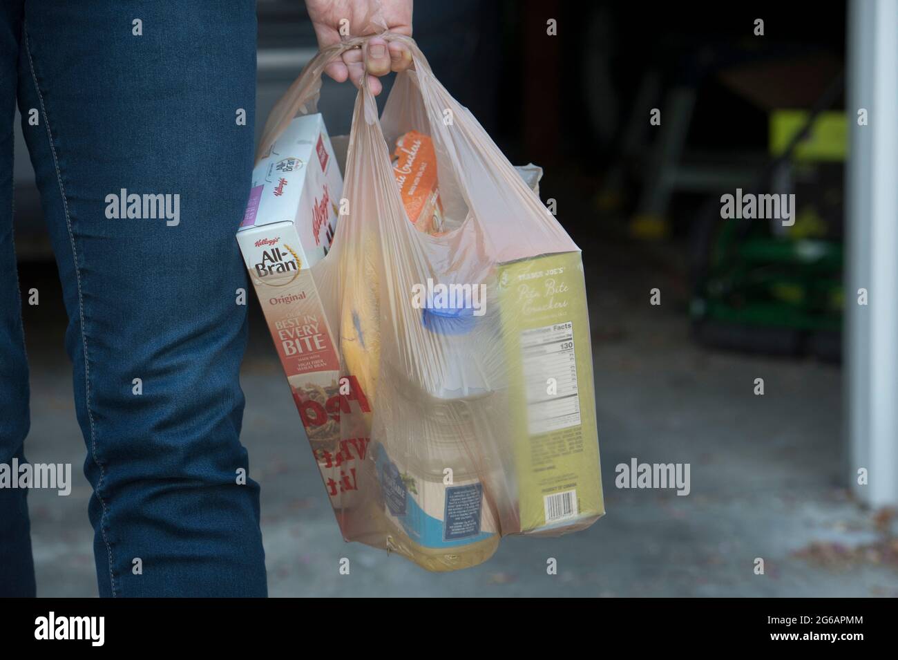 Woman carrying groceries in grocery store plastic bags Stock Photo