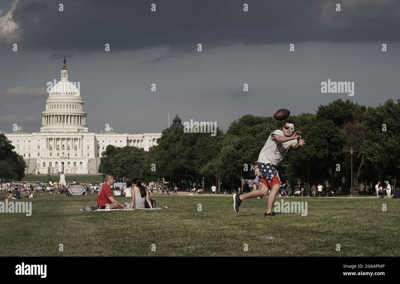 Washington, United States. 04th July, 2021. Scott Phillips plays football on the National Mall as people gather to celebrate America's 245th Independence Day in Washington, DC on Sunday, July 4, 2021. Photo by Ken Cedeno/UPI Credit: UPI/Alamy Live News Stock Photo