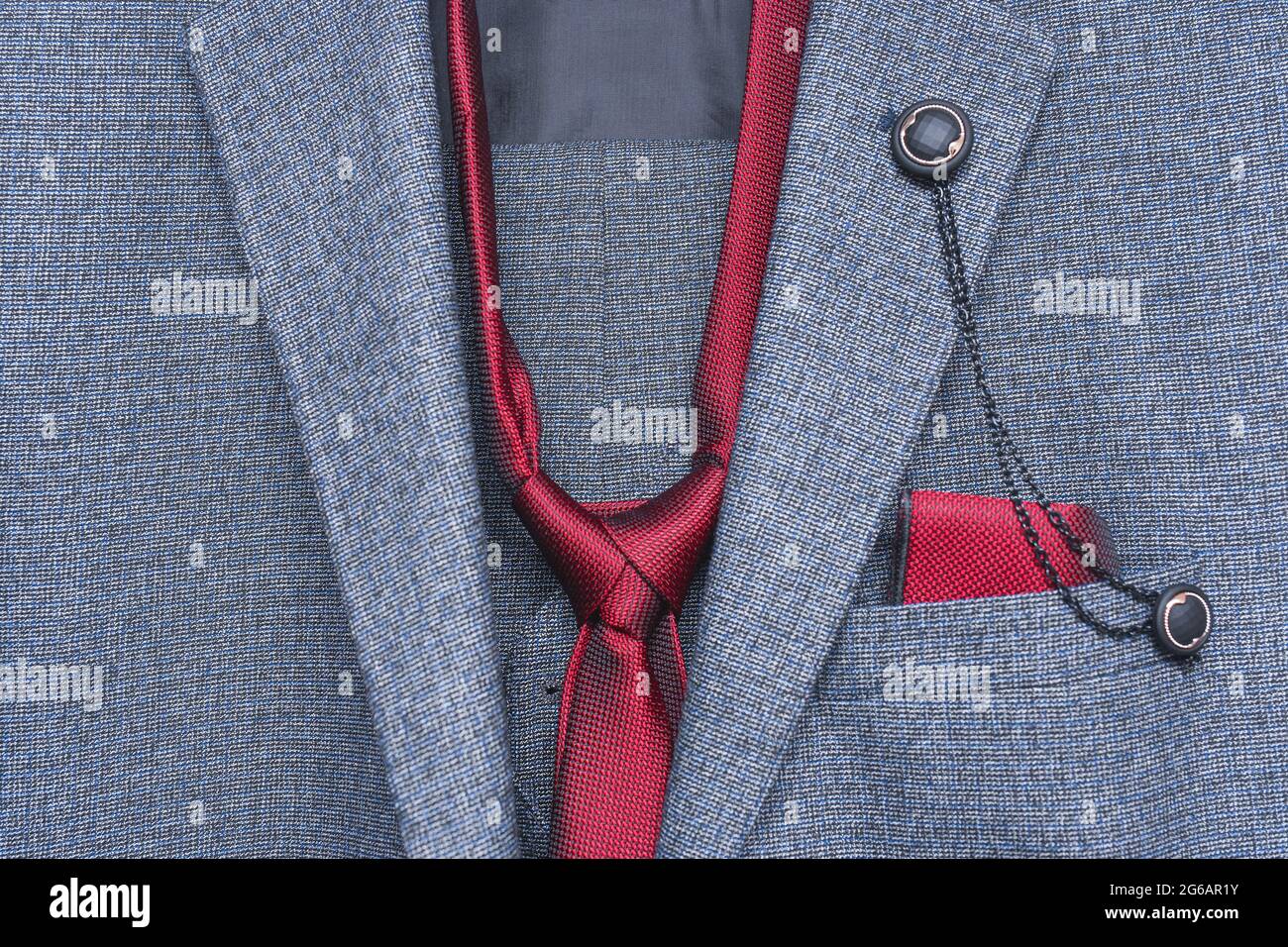 Part or element of a men's suit with a tie and decorative pocket for a napkin with a button close-up. Stock Photo