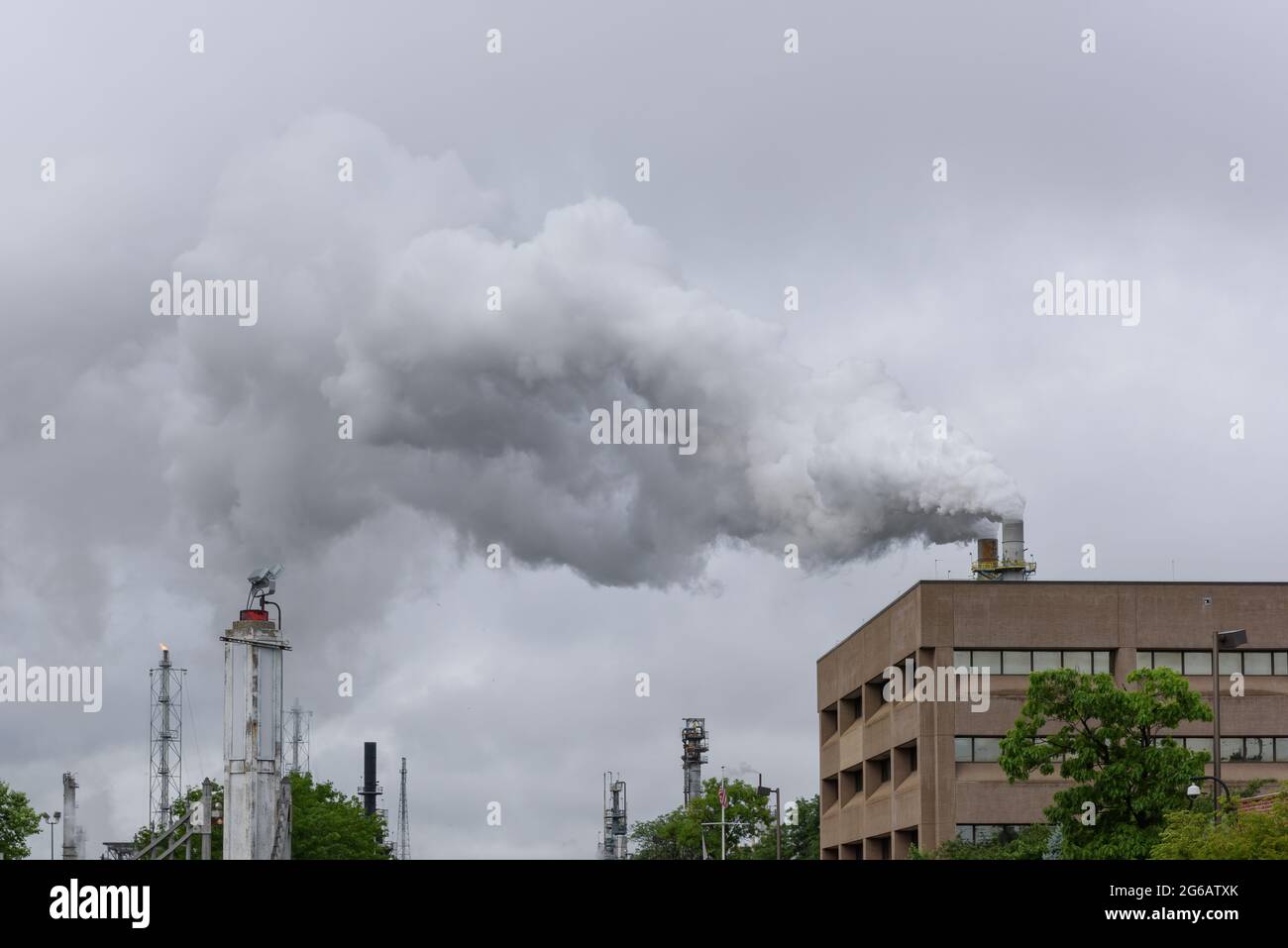 Smoke filled sky polluting the environment from a refinery. Stock Photo
