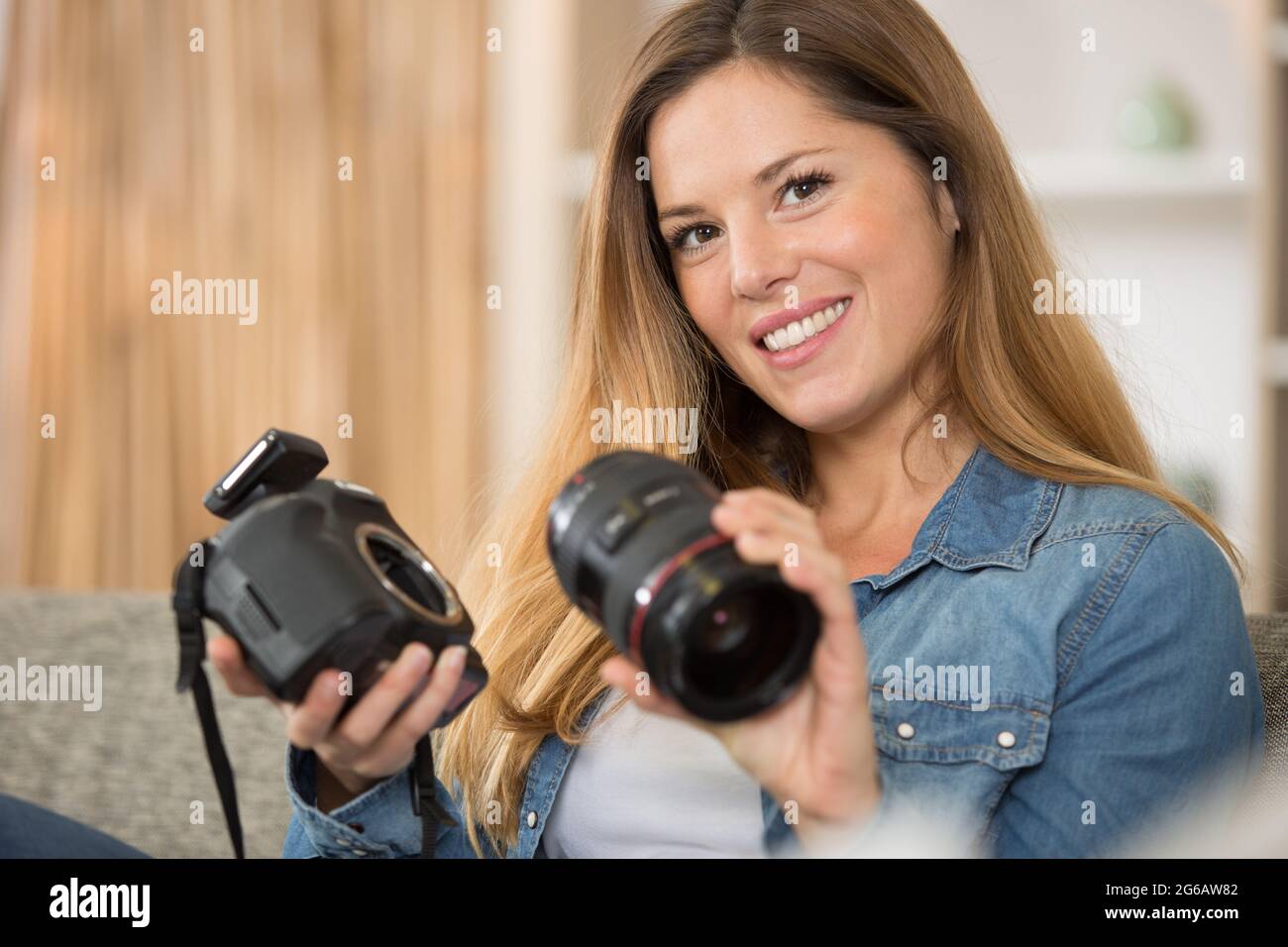 young woman holding camera on the sofa Stock Photo - Alamy