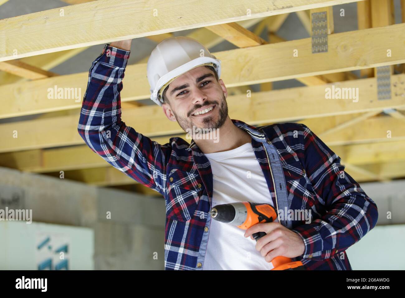 happy male construction worker adjusting ceiling Stock Photo