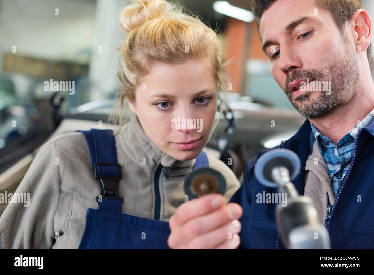 the garage workers holding polisher Stock Photo Alamy