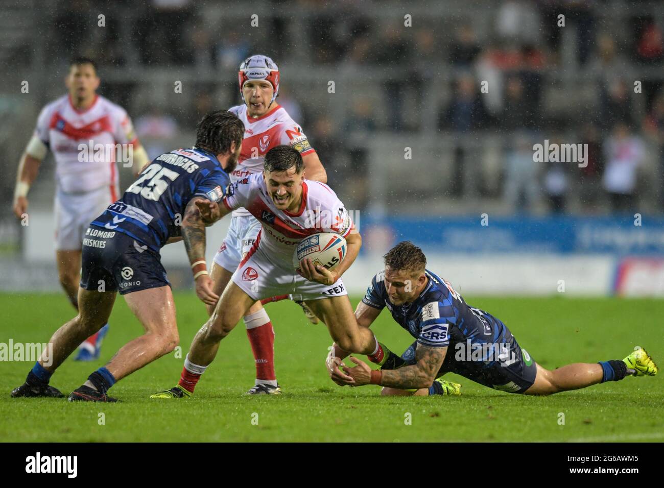 Lewis Dodd (21) of St Helens is tackled by Sam Powell (9) of Wigan Warriors and Joe Shorrocks (25) of Wigan Warriors  in St Helens, United Kingdom on 7/4/2021. (Photo by Simon Whitehead/ SW Photo/News Images/Sipa USA) Stock Photo