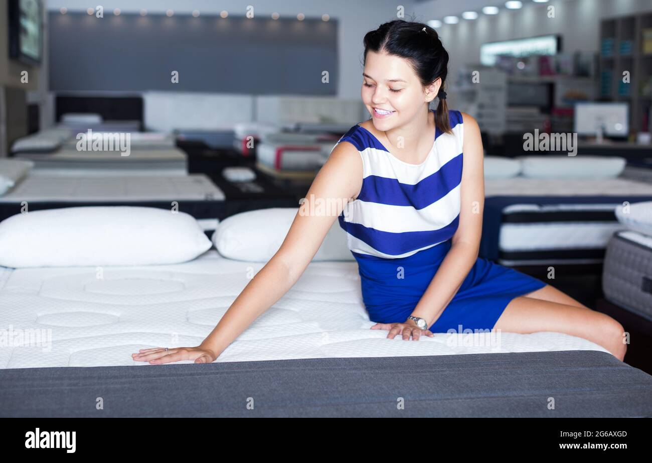 Female sitting on mattress for testing it Stock Photo Alamy