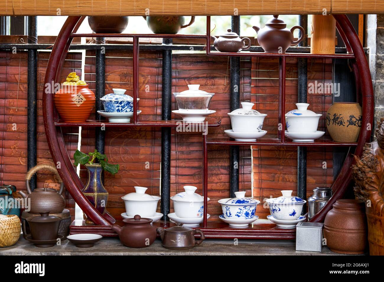 Chinese traditional tea sets, teapots and cups on mahogany shelf Stock