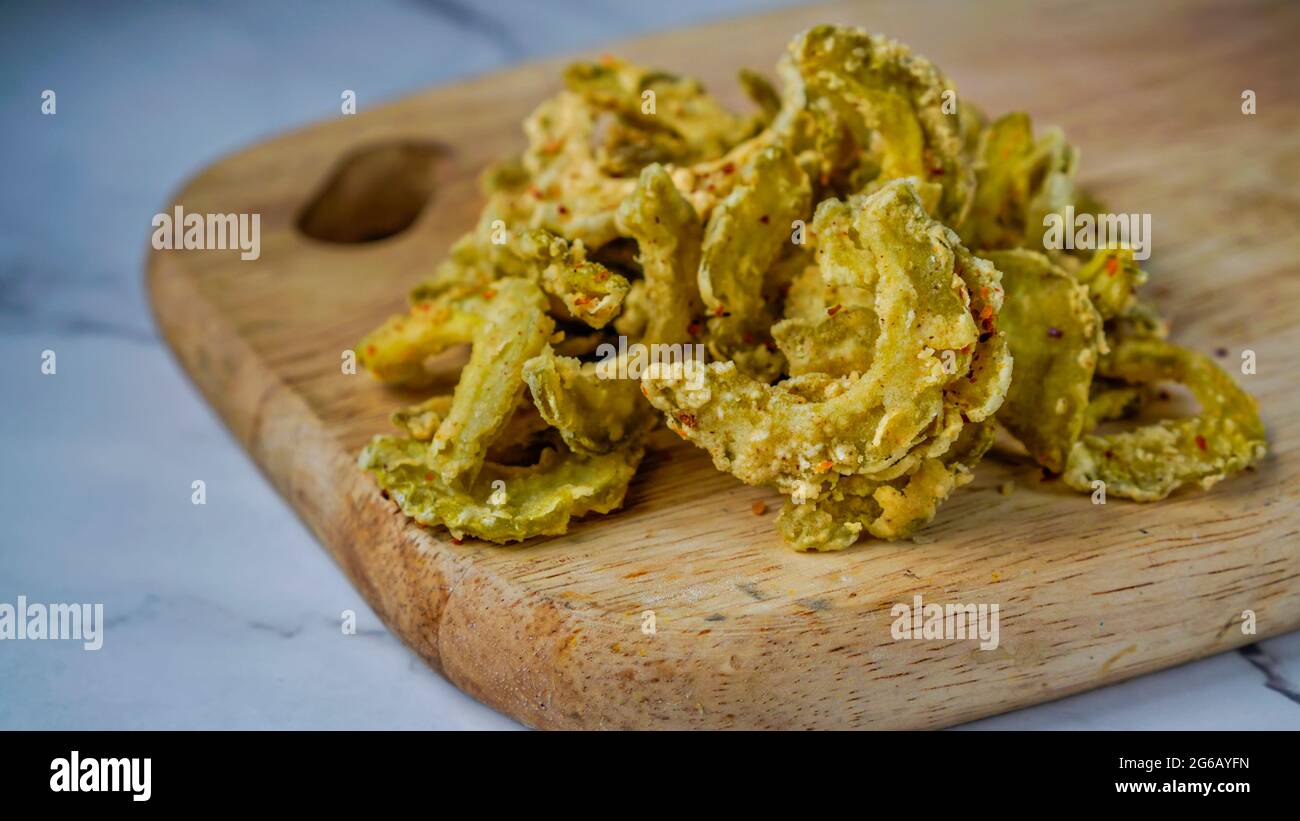 Crunchy deep fried bitter melon with chilli flakes. Delicious snacks. Stock Photo
