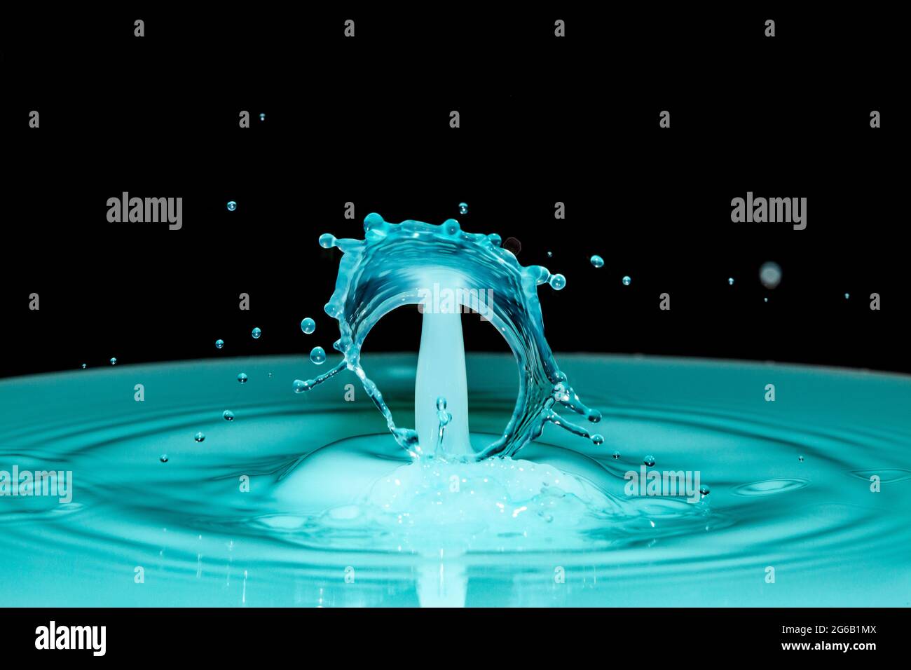 Blue water drop collision over a black background Stock Photo - Alamy