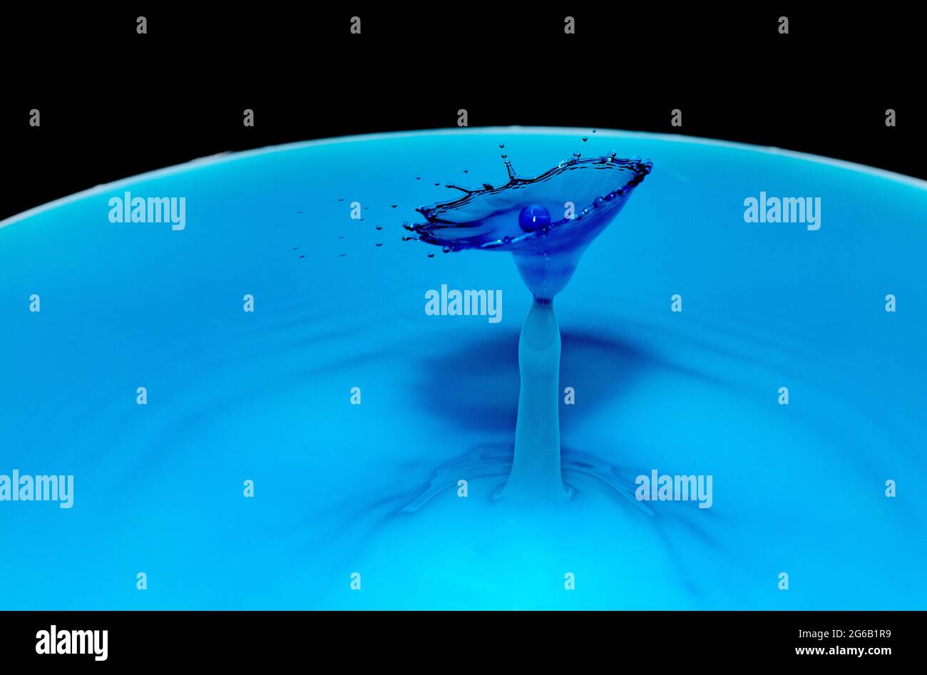 Blue water drop collision over a black background Stock Photo - Alamy
