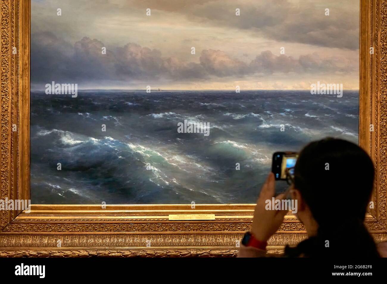 Moscow, Russia. 04th July, 2021. A visitor takes a picture of the Aivazovsky Sea painting on her phone behind the travel exhibits.“Dreams of Freedom. Romanticism in Russia and Germany ”- the largest international exhibition project in the history of the Tretyakov Gallery dedicated to this topic, was developed in cooperation with the State Art Collections of Dresden. This is the first large-scale attempt to compare on one platform the art of the era of romanticism in Russia and Germany. (Photo by Michail Tokmakov/SOPA Images/Sipa USA) Credit: Sipa USA/Alamy Live News Stock Photo