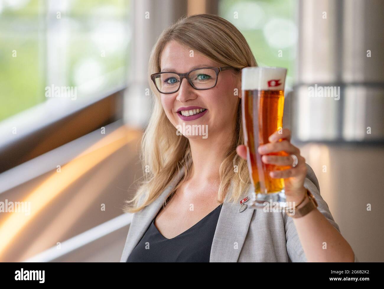Stralsund, Germany. 30th June, 2021. Elisa Raus, the reigning world champion beer sommelier, stands with a glass of beer in the brewhouse at Störtebeker Braumanufaktur. At the 2019 World Championships in Rimini, Italy, she beat off assembled competition from 19 nations. Due to the Corona pandemic, Raus may also be the longest reigning world champion. Credit: Jens Büttner/dpa-Zentralbild/dpa/Alamy Live News Stock Photo