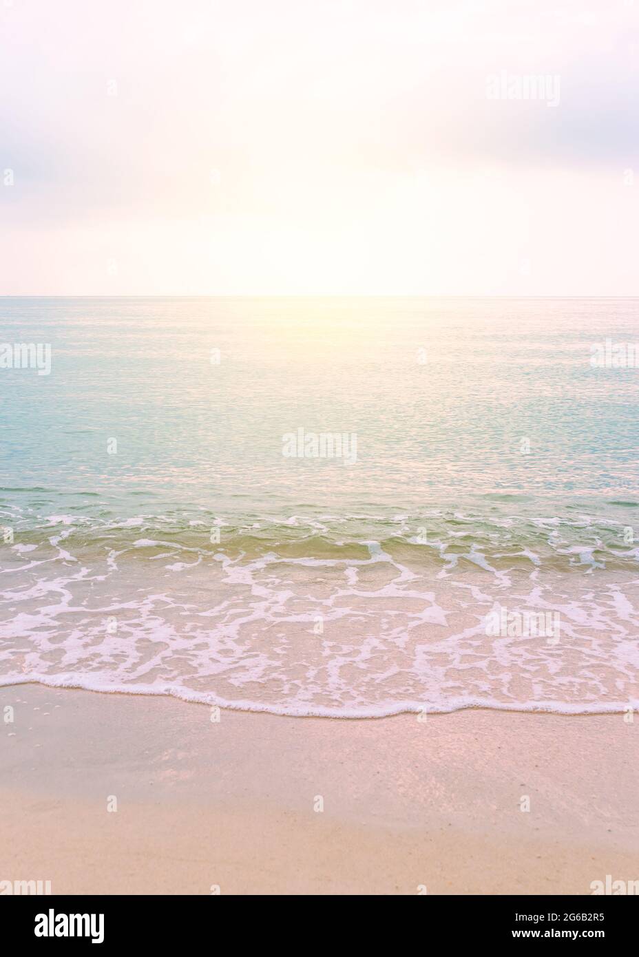 Beautiful tranquil sea beach scene at sunset with warm color grading,  reflection on the water surface, vertical image Stock Photo - Alamy