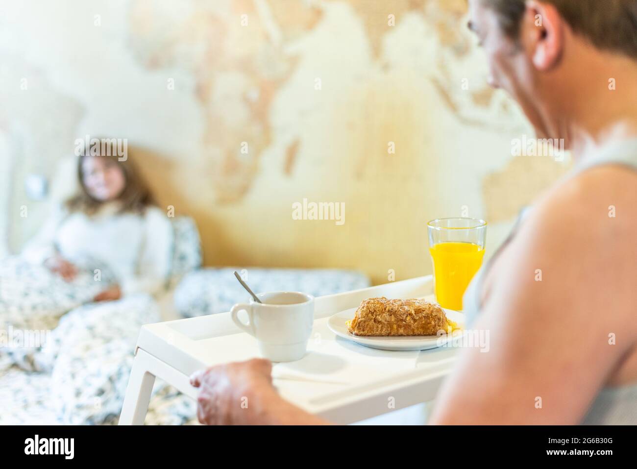 Mature man in love bringing his wife breakfast in bed on a tray. Stock Photo