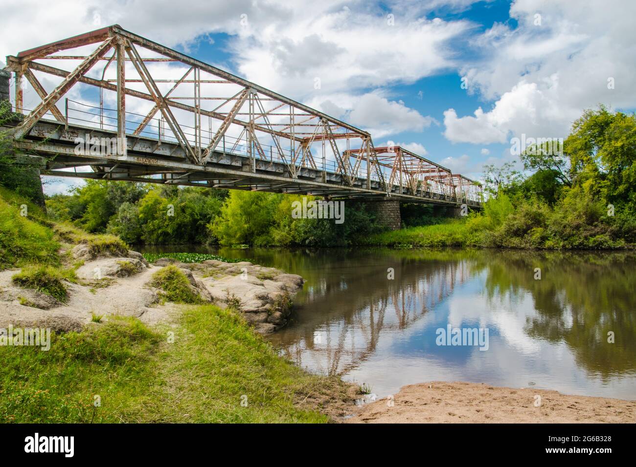 Bridge over a river under a cloudy sky Stock Photo - Alamy