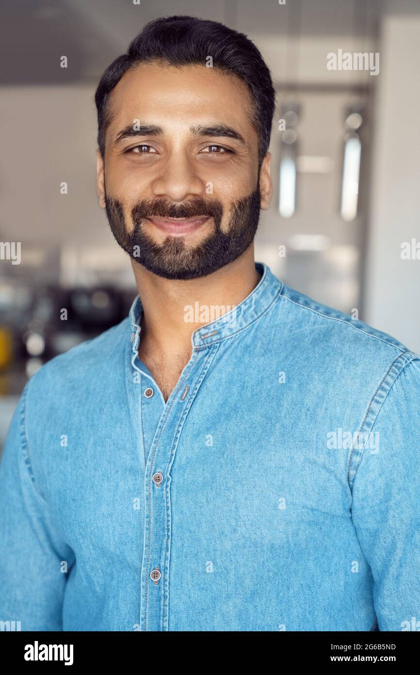 Closeup portrait of indian businessman smiling to camera over blurred background Stock Photo