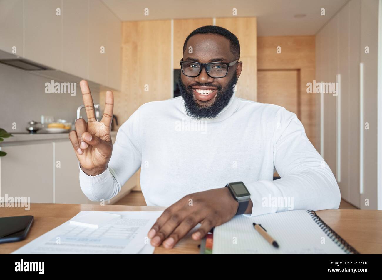 Portrait of glad excited man coach or student showing v-sign smiling at camera Stock Photo