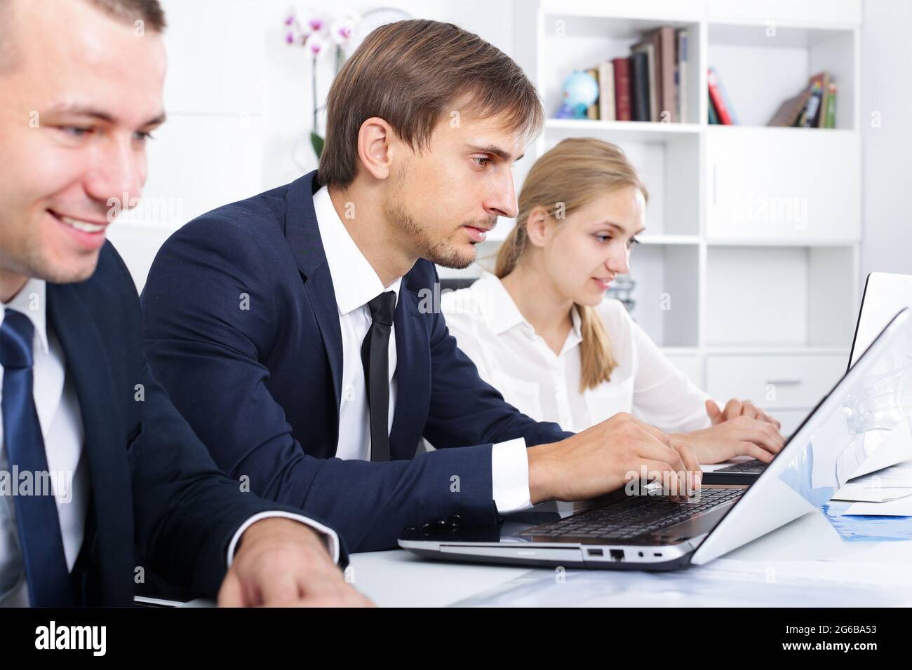 Serious young male manager working on laptop in office Stock Photo - Alamy