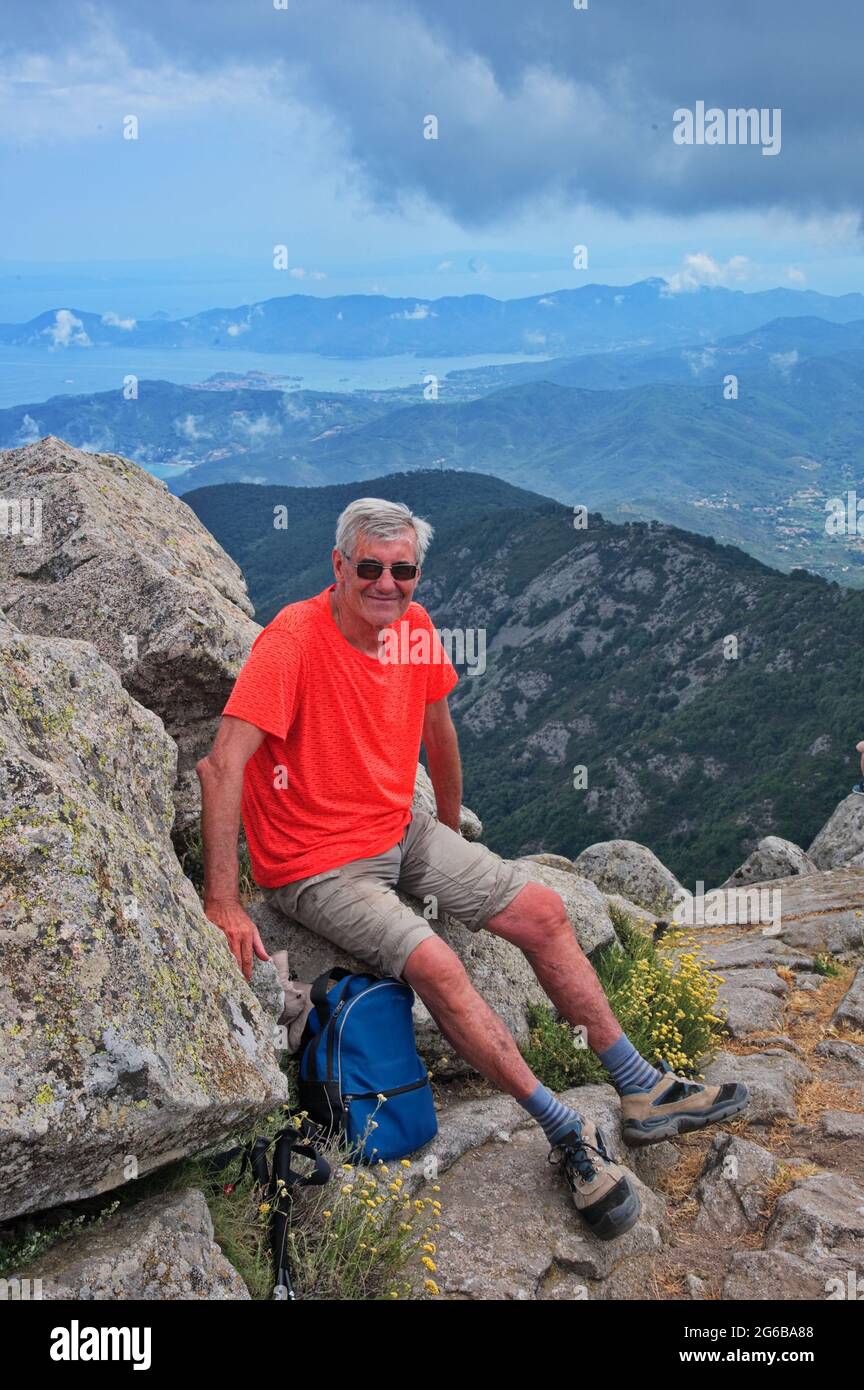 Senior man hiking in mountains and sitting on the rock Stock Photo - Alamy