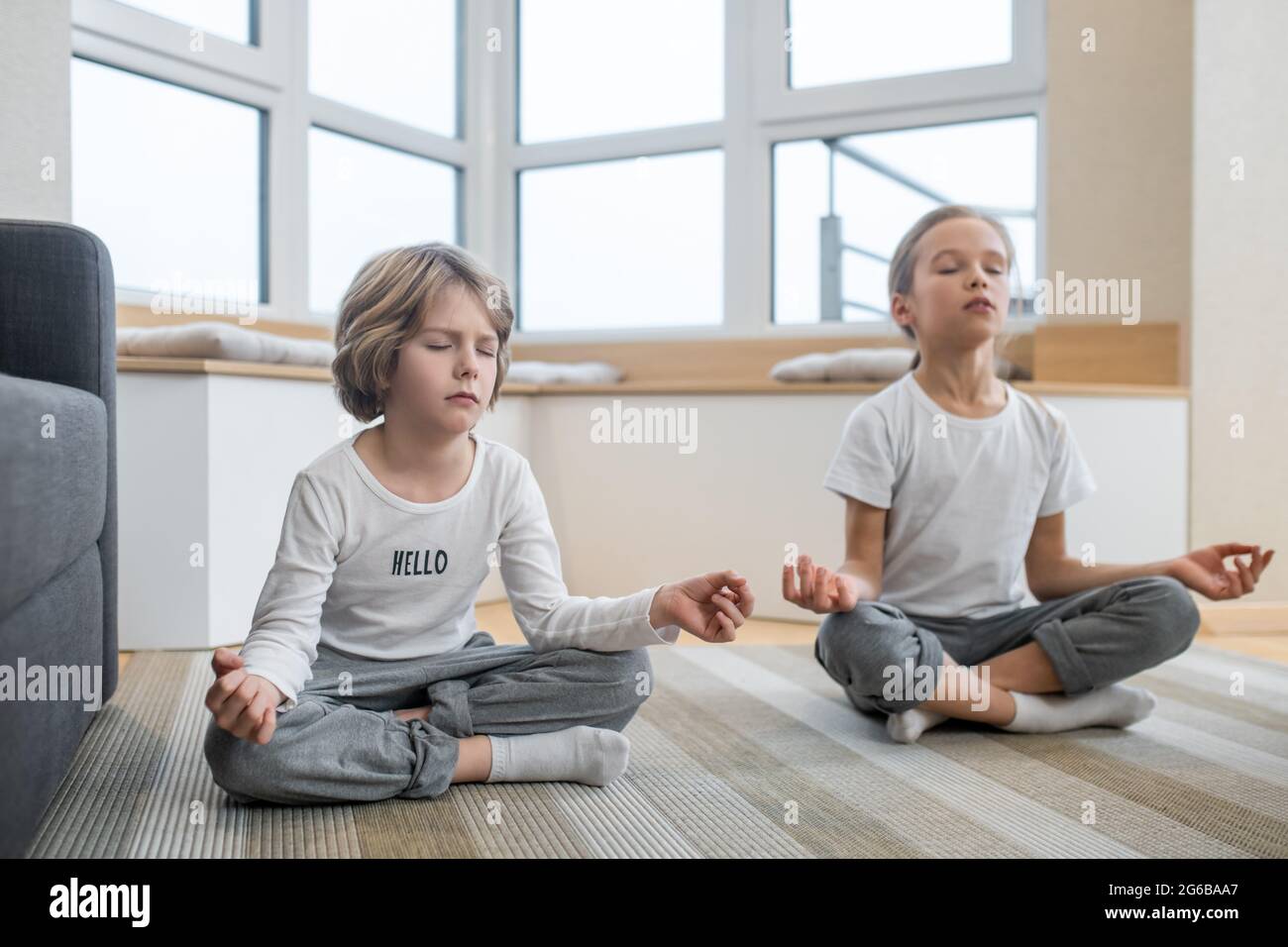 Kids doing yoga together at home and sitting in meditation Stock Photo ...