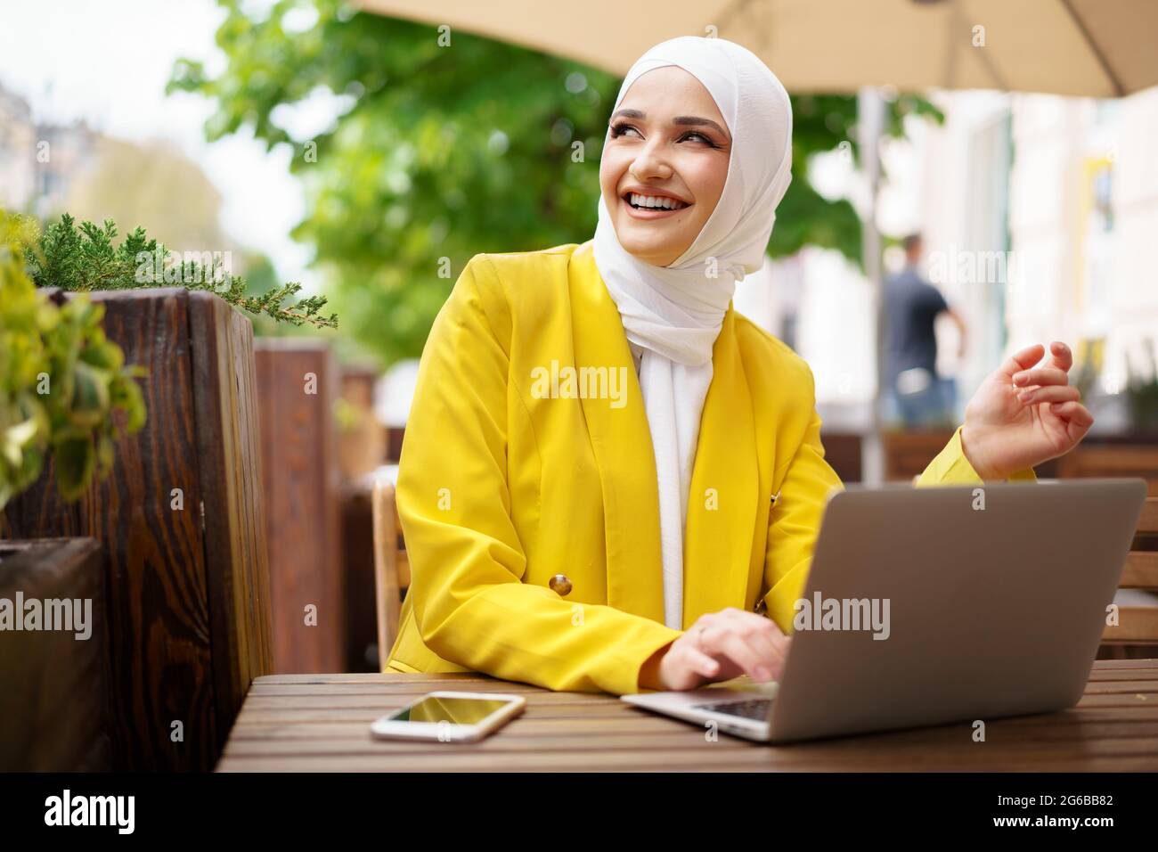 Beautiful smiling muslim woman with laptop at cafe Stock Photo - Alamy
