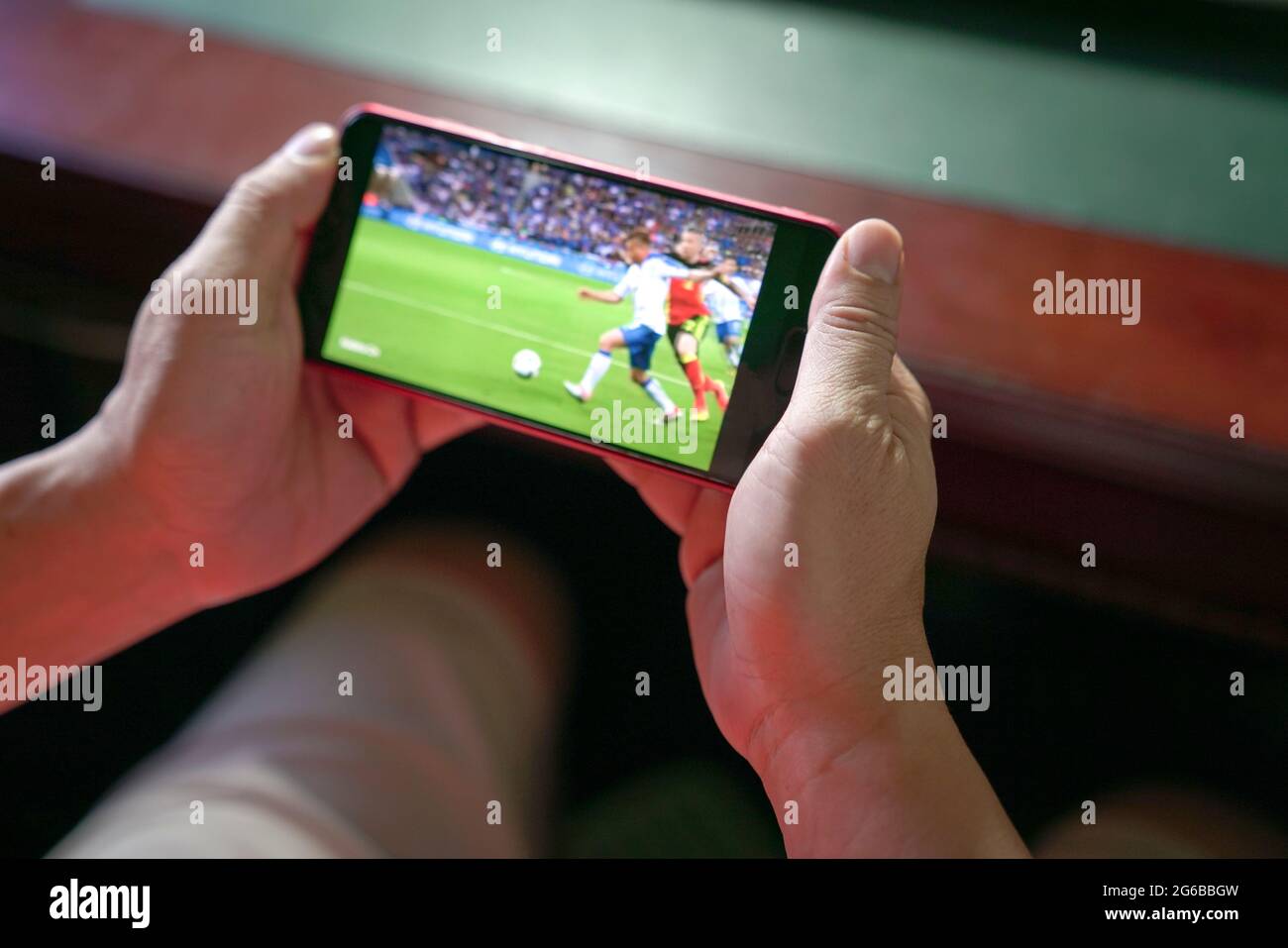 Man watching football and sport stream on mobile phone. Close up view. Home entertainment concept. Stock Photo
