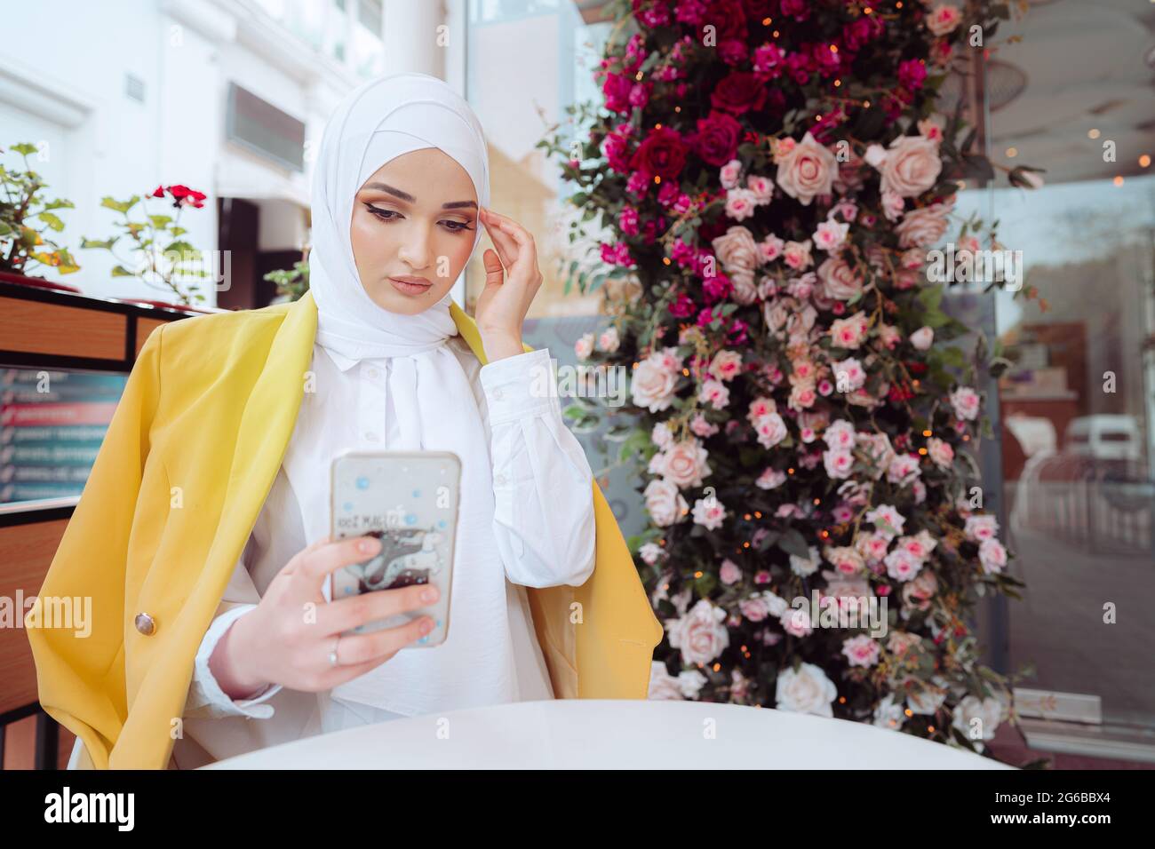 Young muslim woman in hijab using her smartphone in cafe Stock Photo ...