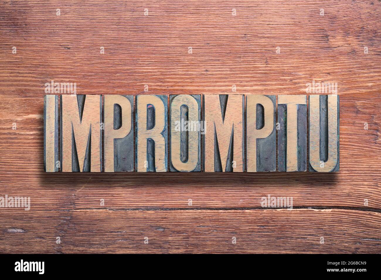 impromptu word ancient Latin word meaning - spontaneous, combined on vintage varnished wooden surface Stock Photo